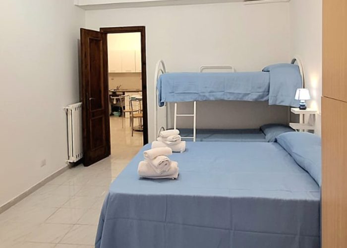camera con letto matrimoniale e letto a castello nell’appartamento mare fuori a ladispoli
