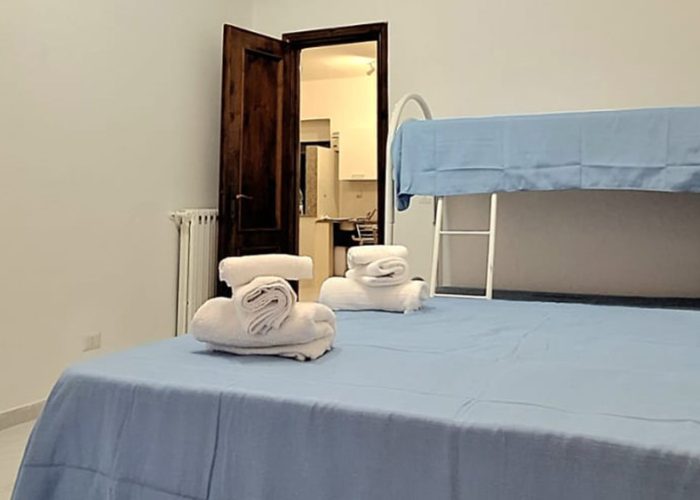 camera da letto con letto matrimoniale e letto a castello nella casa vacanze Mare Fuori a ladispoli