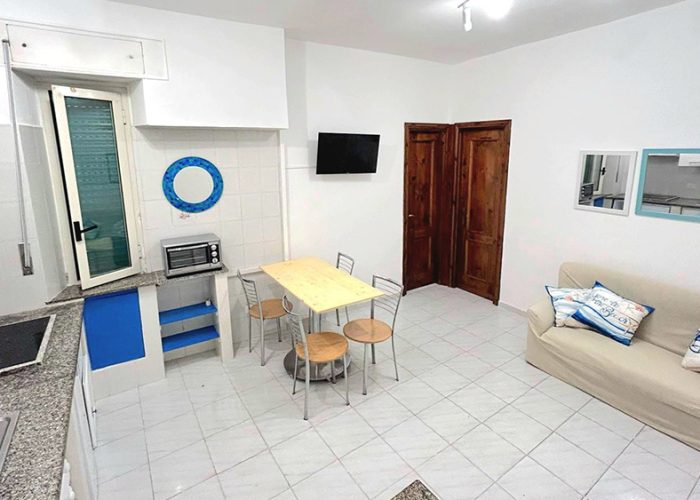 soggiorno con cucina tavolo da pranzo e divano nell’appartamento mare fuori, una delle nostre Case Vacanza a Ladispoli