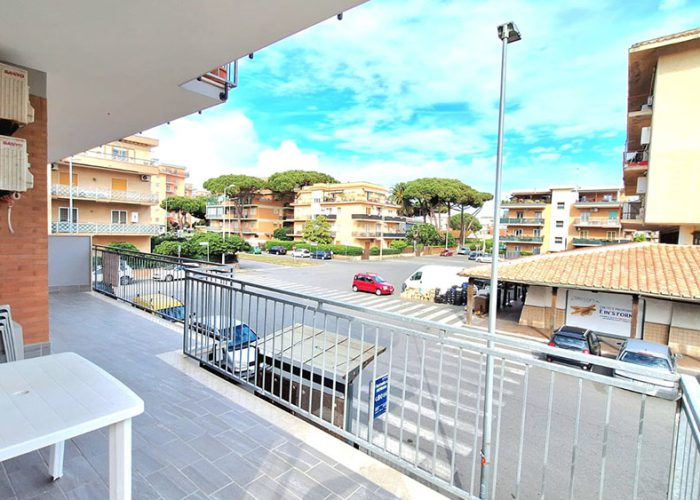 Vista dal balcone di una delle case vacanza a Ladispoli, con terrazza arredata, tavolino, sedie e panorama urbano