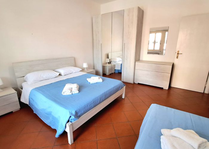 camera matrimoniale spaziosa con letto matrimoniale, letto singolo e arredamento moderno delle nostre Case Vacanza a Ladispoli