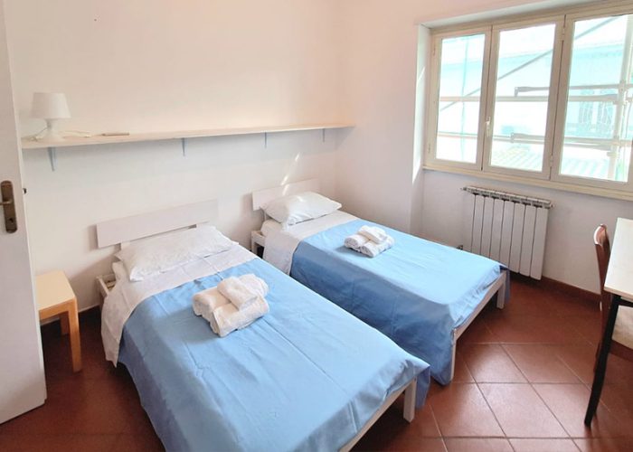 Camera doppia con letti singoli e finestra luminosa nell’appartamento Terrazza del Mare, parte delle nostre case vacanza a Ladispoli